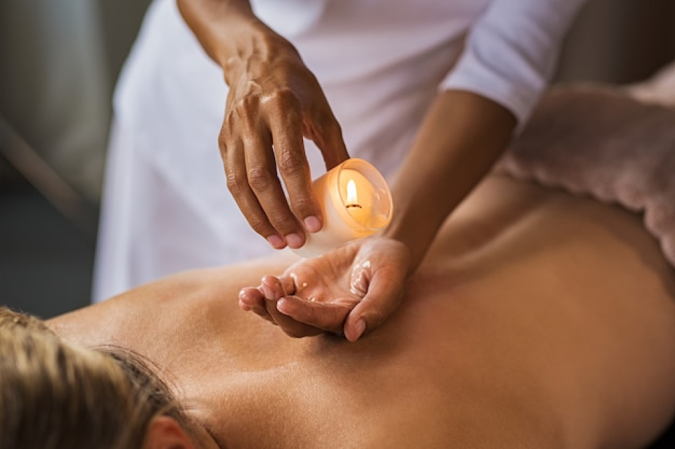 Professional Candle Therapy treatment with essential oils in serene spa environment